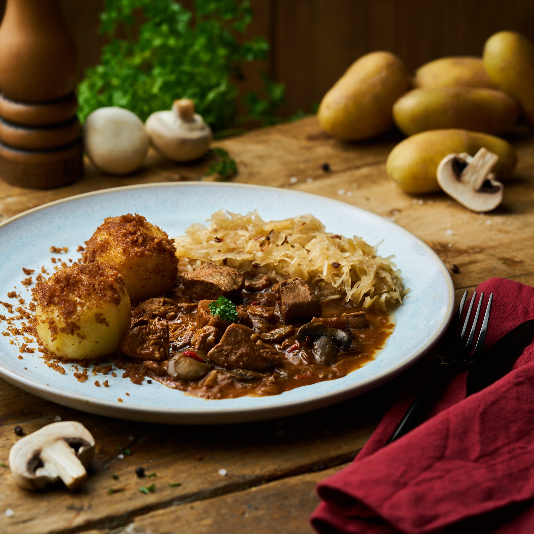 Brauhausgulasch vom Schwein mit Sauerkraut und Kartoffelklöße