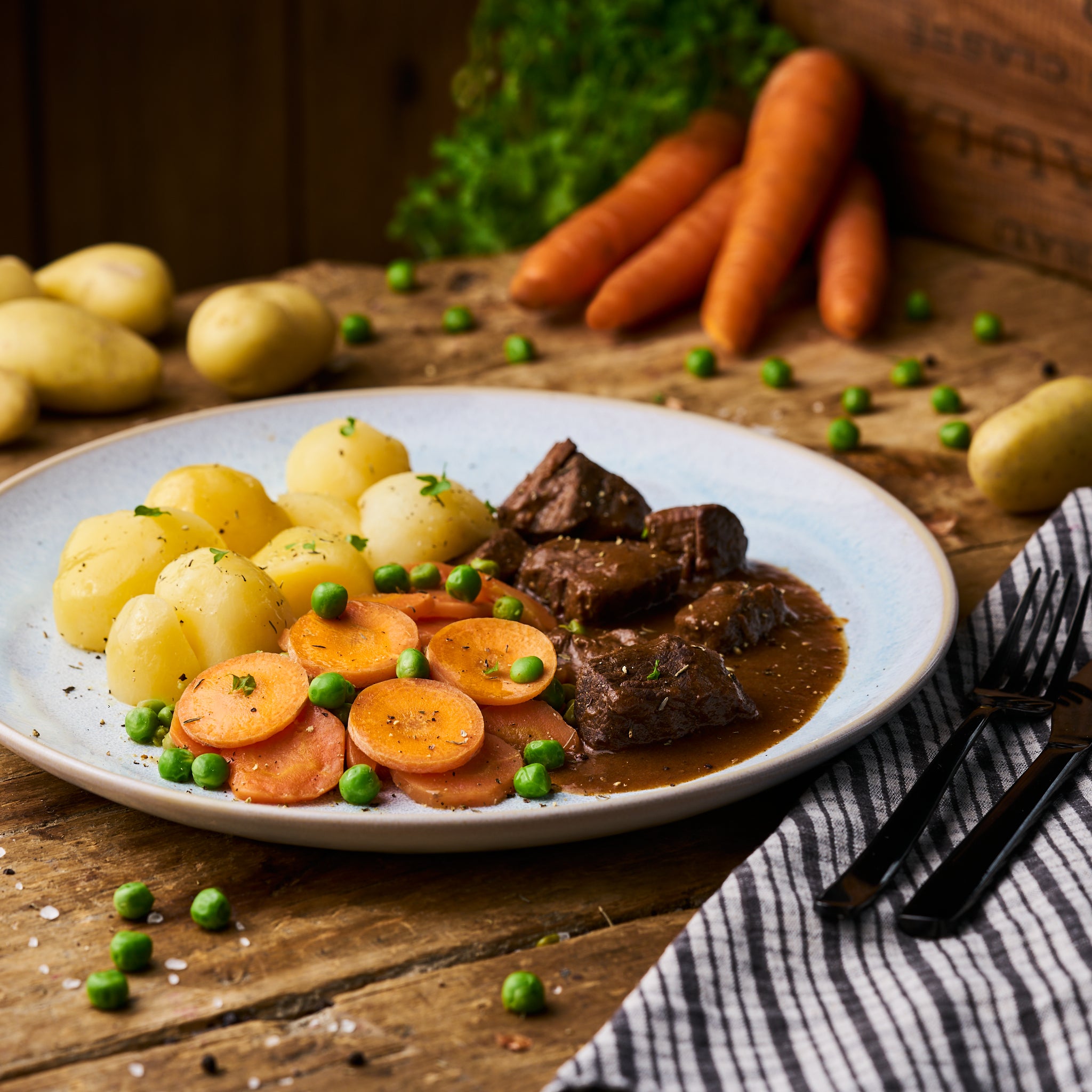 Rotweingulasch vom Rind mit Erbse-Möhre und Butterkartoffeln